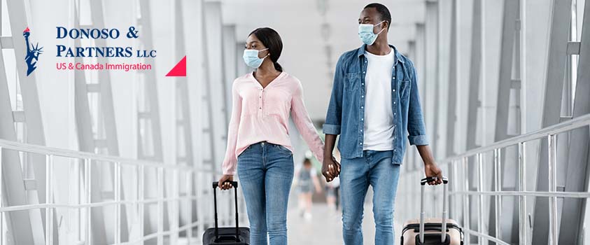 couple wearing masks holding hands in airport
