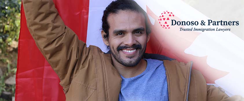 Man smiling, holding Canadian Flag